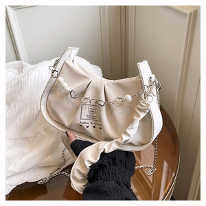 Detail of cream pleated baguette bag with pearl flower chain and adjustable straps