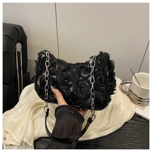 Detail einer eleganten schwarzen Netztasche mit 3D-Rosen und silbernem Kettenriemen