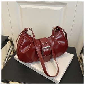 Detail of burgundy crescent moon bag featuring pleated leather and a metallic buckle