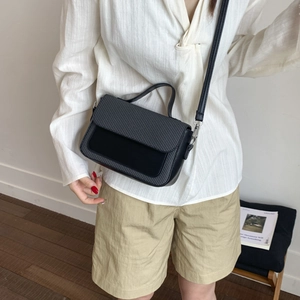 Fashionable black crossbody bag with woven texture and smooth leather finish for women