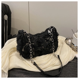 Detail der schwarzen Schultertasche mit 3D-Rosen-Texturen und Metallkettenriemen
