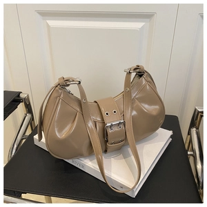 Detailed view of khaki patent leather crescent bag with silver buckle and side pleats