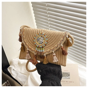 Detail of bohemian woven straw bag with colorful bead mandala and tassel charm