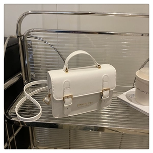 Detail of white PU leather crossbody bag with gold buckles and JINGPINPJ logo