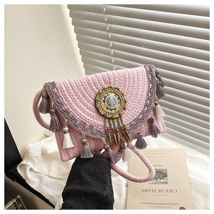 Detail of pink woven crossbody bag with colorful tassels and ethnic beaded embellishment