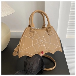 Detail of bat-shaped camel handbag with white spiderweb stitching and round top handles