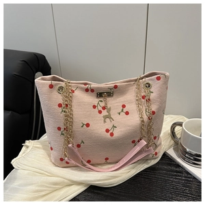 Nahaufnahme der rosa Cord-Tragetasche mit Kirschmuster und goldenem Hirsch-Anhänger