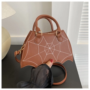 Close-up of brown bat-wing crossbody bag with white spider web stitching and gold hardware