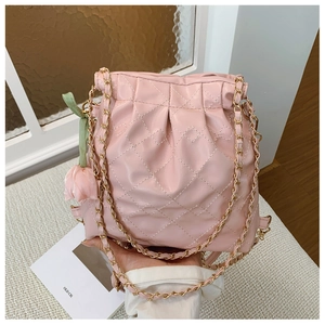 Pink quilted bucket bag detail with drawstring closure and tulip charm accessory