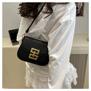 Detailansicht einer schwarzen Leder-Satteltasche mit markanter goldener Rechteck-Schnalle