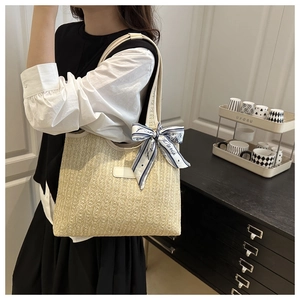 Close-up of knit tote bag with vertical texture and printed silk scarf handle detail