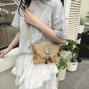 Bohemian woven straw shoulder bag with colorful beads, fringe, and lace trim detail