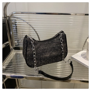 Détail du sac à épaule en denim à pois noirs avec chaîne argentée et fermeture éclair