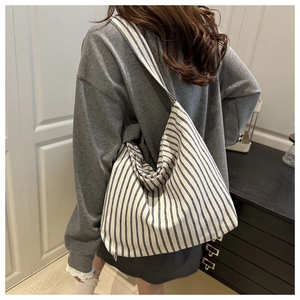 Detail of minimalist striped canvas tote bag showing its large capacity and soft silhouette