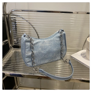 Détail du sac bandoulière en denim bleu clair avec cristaux et chaîne argentée