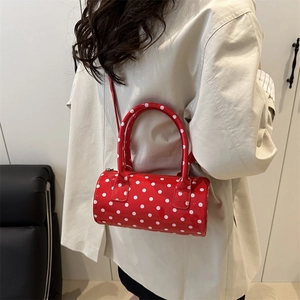 Red cylindrical polka dot shoulder bag with glossy finish and double handles for women