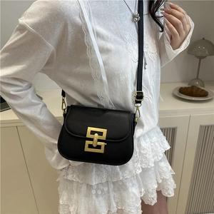 Minimalist black leather crossbody bag with golden geometric buckle for modern women