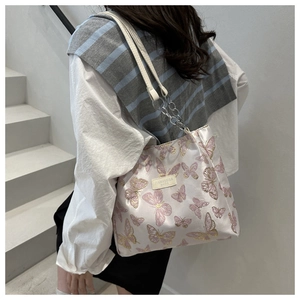 Détail du sac à bandoulière rose clair avec imprimé papillon et chaîne argentée