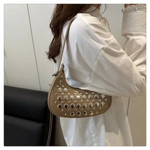Close-up of khaki leather crescent bag with silver studs and punk style shoulder strap