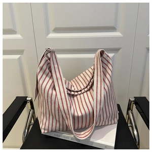 Detail of red and white striped canvas tote bag showing thick shoulder strap and large capacity