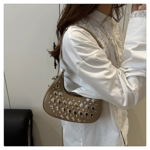 Detail view of retro half-moon shoulder bag with silver rivets and smooth zipper closure