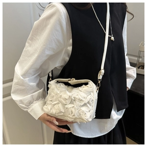 Détail d'un sac bandoulière blanc orné de décorations florales roses 3D en mousseline