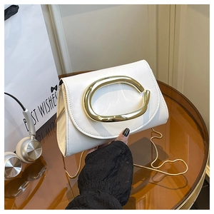 Détail d'un sac à bandoulière en cuir blanc avec boucle ovale dorée et chaîne raffinée