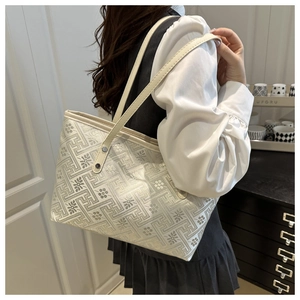 Detail view of large tote bag with geometric floral jacquard pattern and slim shoulder straps