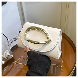 Détail d'un mini sac carré blanc crème avec poignée ovale dorée et bandoulière chaîne