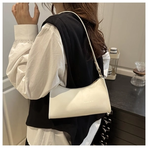 Side view of white glossy baguette shoulder bag with smooth patent leather texture