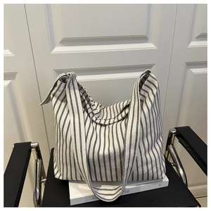 Detail of large canvas tote bag featuring classic black and white vertical stripes design
