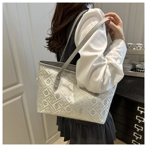 Detail view of large tote bag with geometric embroidery and grey shoulder straps