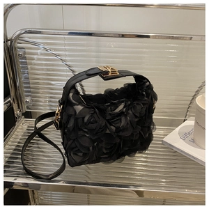 Détail de fleurs de rose 3D sur un sac noir avec une boucle métallique dorée chic