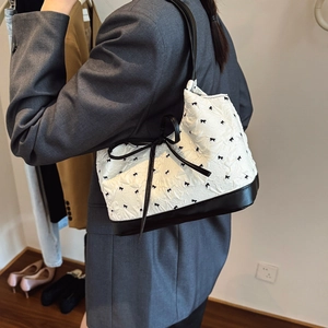 Chic white shoulder bag with black bow patterns and leather strap for women
