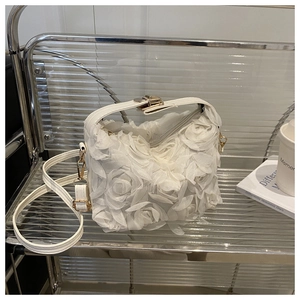 Détail de la texture rose 3D blanche et du fermoir en métal doré d'un sac de soirée chic