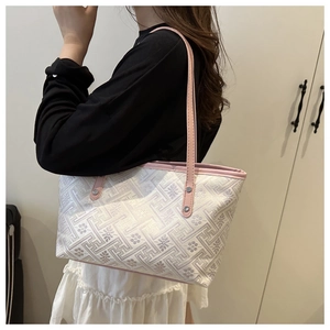 Side view of large geometric jacquard tote bag with pink leather straps worn by model