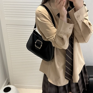 Minimalist black leather underarm bag with gold buckle on casual preppy outfit