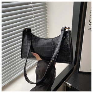 Close-up of black crocodile embossed shoulder bag with premium golden metal zipper and hardware