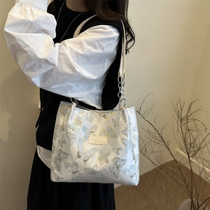 Sac bandoulière blanc chic avec broderies papillon bleu et or et bandoulière argentée