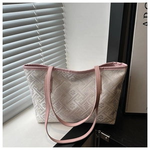 Detail of jacquard woven tote bag with pink leather trim and elegant geometric pattern