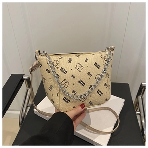 Dettaglio della borsa a secchiello in pelle beige martellata con orsetti e fiocchi stampati