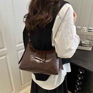 Minimalist dark brown polished leather underarm bag with sleek silver metal trim detail