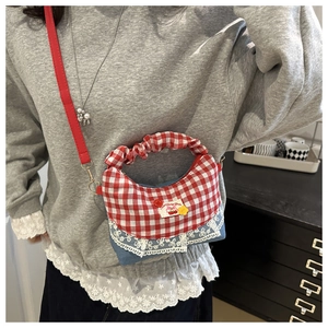 Detail of sweet cherry garden patch on denim and plaid crossbody bag with lace trim