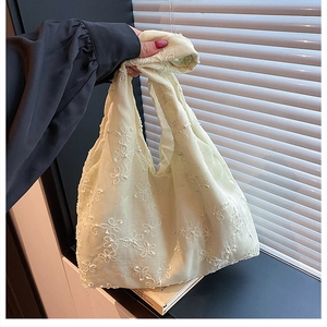 Détail de la broderie florale et de la poignée nouée sur le sac cabas en lin vert