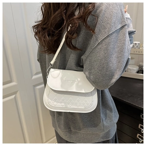 Détail du sac selle blanc avec lettrage FASHION TREND et texture matelassée