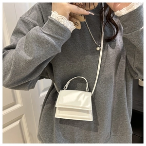 Mini white leather crossbody bag shown on model for size perspective and style