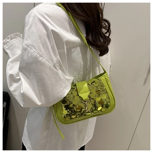 Détail du sac sous l'aisselle à paillettes vert néon avec paillettes dorées et bandoulière
