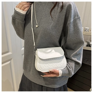 Vue détaillée d'un sac à bandoulière matelassé blanc avec bandoulière réglable sur modèle
