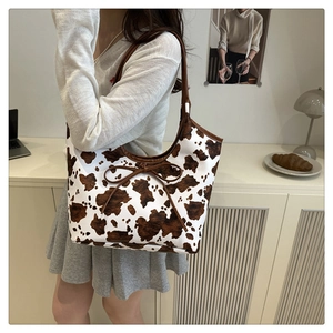 Detail of a leopard print tote bag featuring a decorative bow and stylish shoulder strap