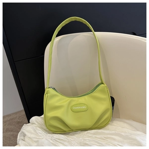 Detail of neon green pleated PU leather shoulder bag with zipper and fashion label